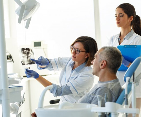 a dentist showing a patient their dental X-ray