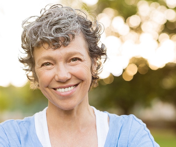 an older woman smiling while outside