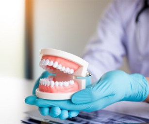 dentist holding dentures in hand
