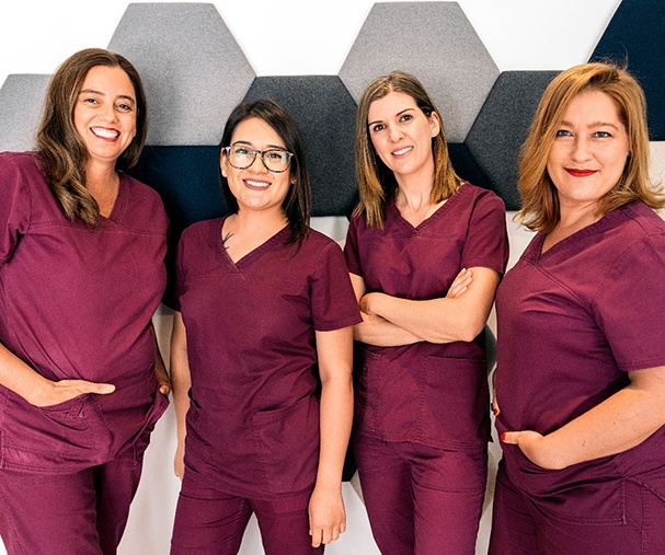 Four female dental team members smiling
