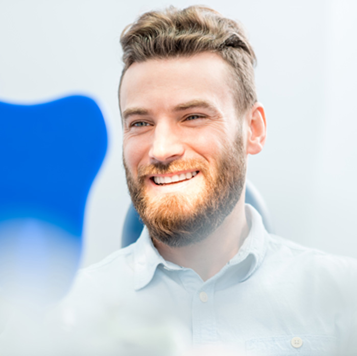 Man smiling while looking at reflection in mirror