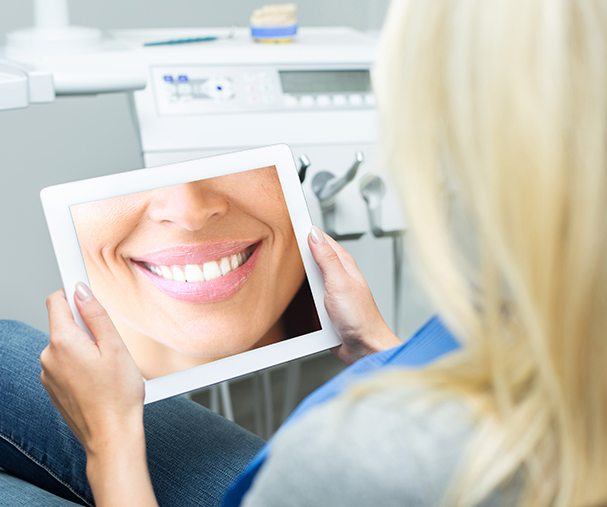 Woman looking at smile design on tablet computer