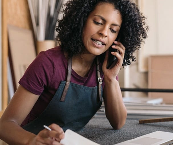 business person talking on the phone and looking at a piece of paper