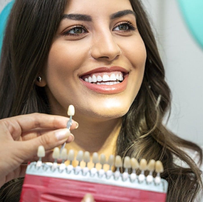 dentist matching the shade of a patient’s teeth for their dental crown in Sparta