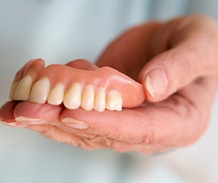 a closeup of someone holding their dentures