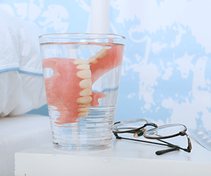 dentures soaking in a glass of water