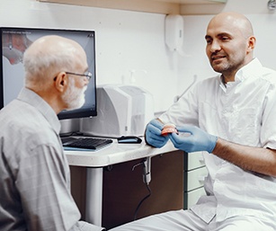 Dentist explaining cost of dentures in Sparta to a patient