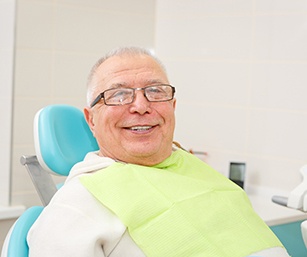 Older man with dentures in Sparta smiling at the dentist