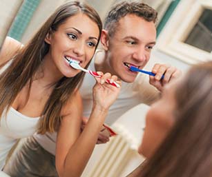 Couple brushing their teeth to prevent dental emergencies in Sparta