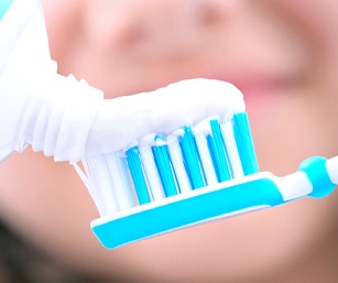 Close-up of squeezing toothpaste onto a toothbrush