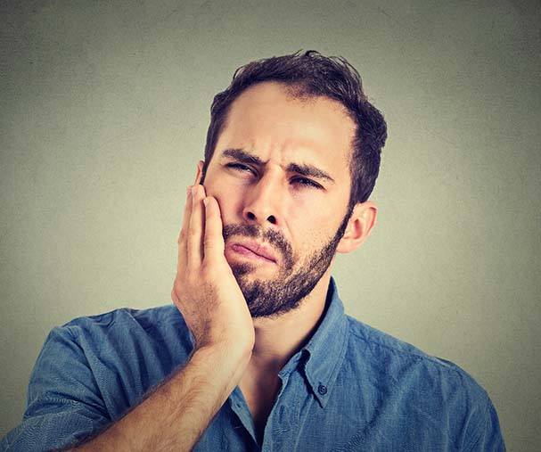 Man with tooth pain in need of Sparta emergency dentist