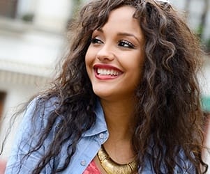 Young woman smiling and wearing denim shirt