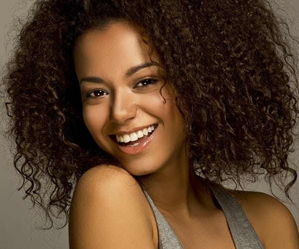 Young woman wearing gray top and smiling