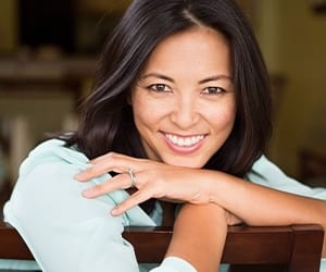 Smiling woman leaning over back of chair