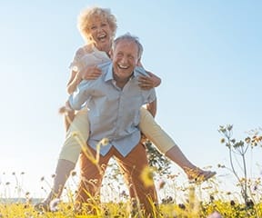 Senior couple enjoying good health with help of dental implants