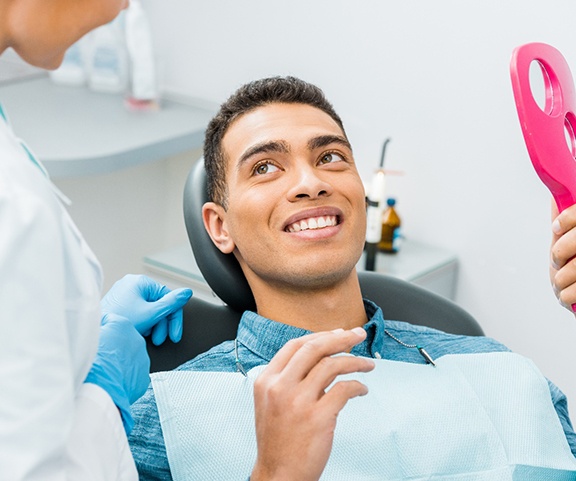 Patient smiling with an implant dentist in Sparta