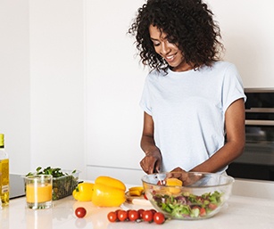 Smiling woman preparing healthy meal at home