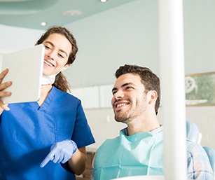 Dentist showing patient image on tablet