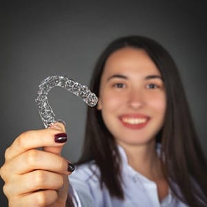 woman holding Invisalign in Sparta