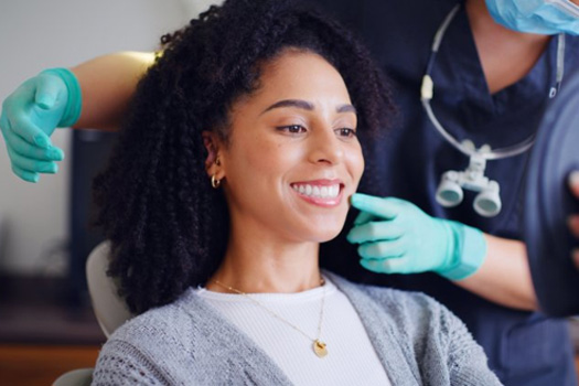 a patient checking her smile with a mirror