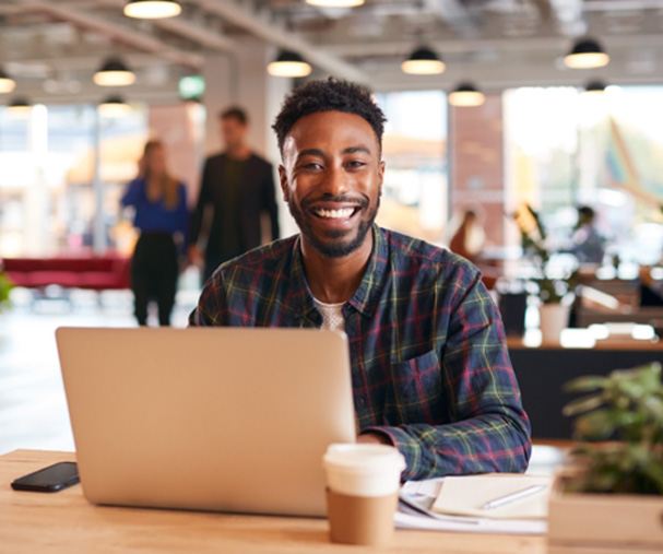 Man smiling while working on laptop in office