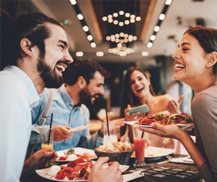 Friends laughing while eating meal at restaurant