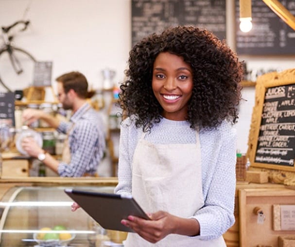 worker smiling and holding a tablet