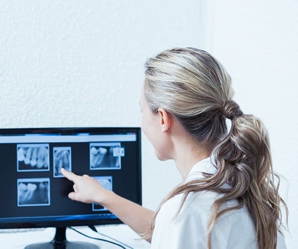 Dentist looking at dentla x-rays on computer