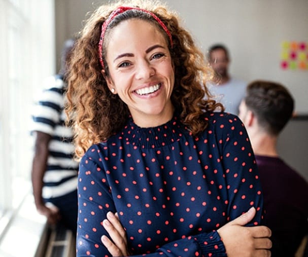 person smiling and crossing their arms