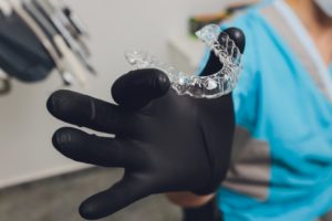 dentist holding clear aligners