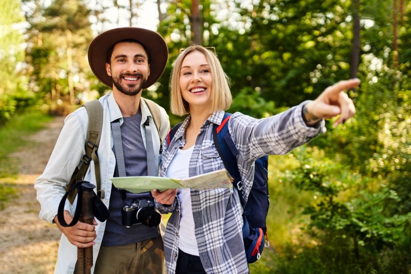 couple smiling in woods during summer vacation