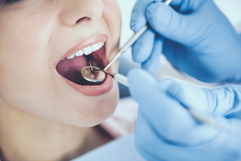 A dentist performing an oral cancer screening in Sparta