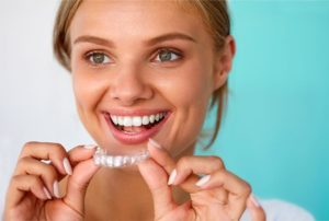 a patient holding their Invisalign aligner 