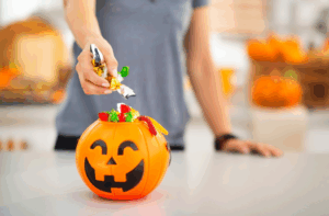 a person grabbing a handful of Halloween candy