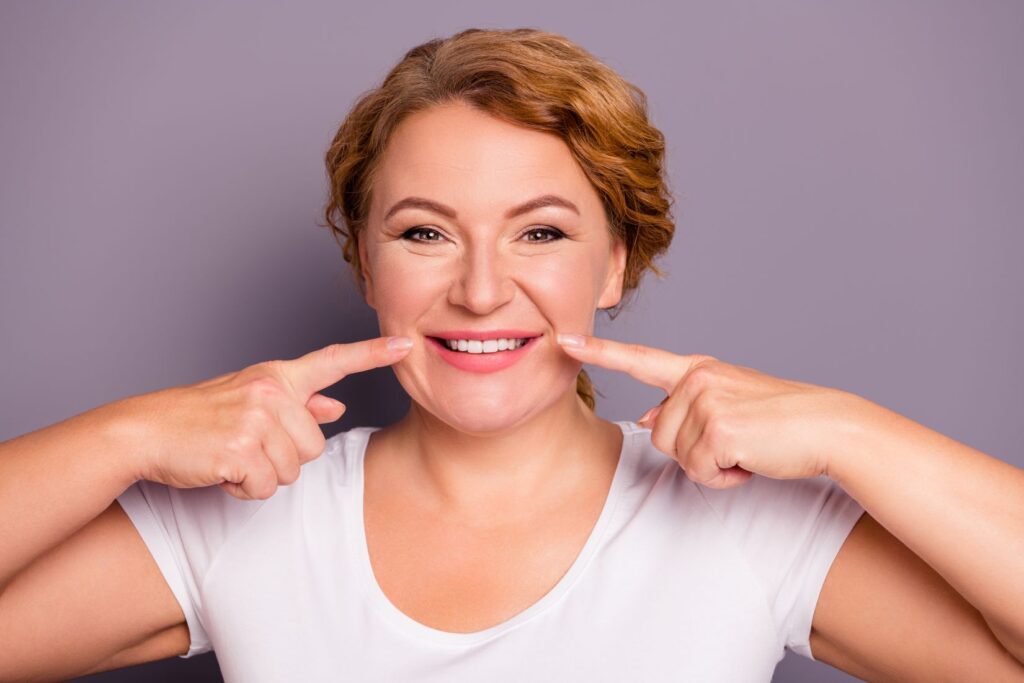 A woman pointing at her gums
