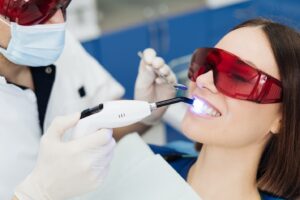 Patient having teeth whitened by dentist.